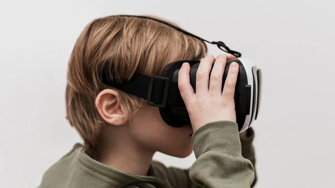 Seitenansicht eines kleinen Jungen, der ein Virtual-Reality-Headset benutzt.
